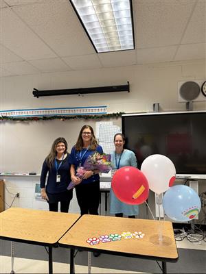 3 teachers in classroom setting with balloons and flowers